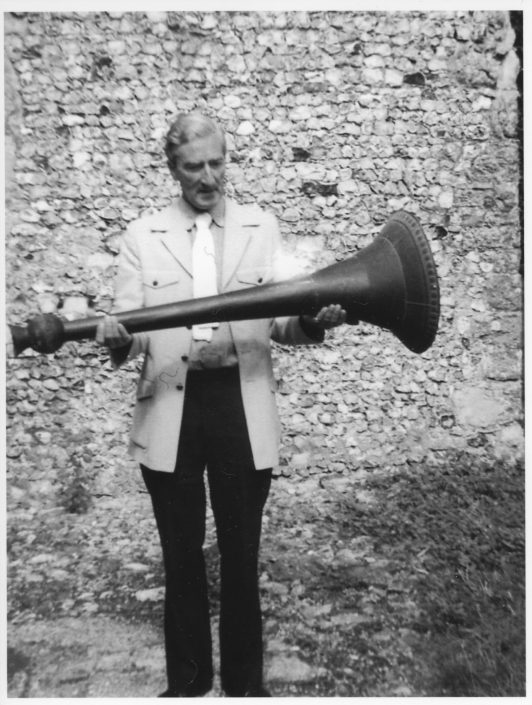 A historical photo of a man holding a metal object